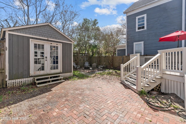 view of patio with an outdoor fire pit, fence, and an outbuilding