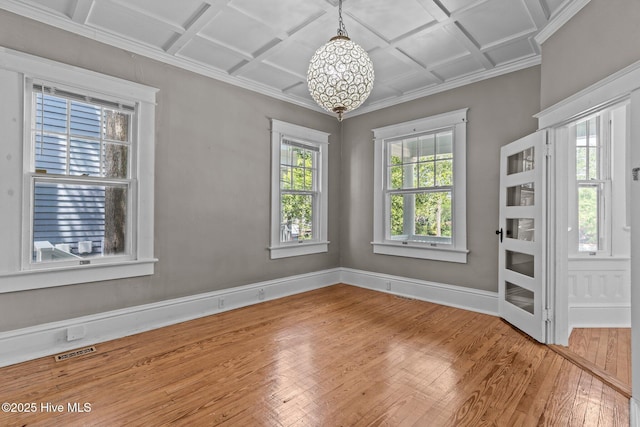 unfurnished dining area with baseboards, visible vents, ornamental molding, hardwood / wood-style flooring, and coffered ceiling