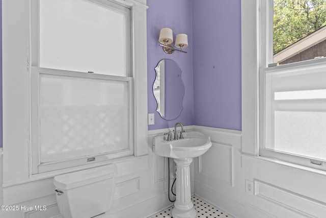 bathroom featuring toilet and wainscoting