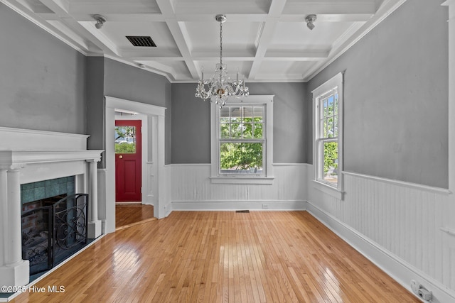 unfurnished living room with a wainscoted wall, hardwood / wood-style flooring, and a wealth of natural light