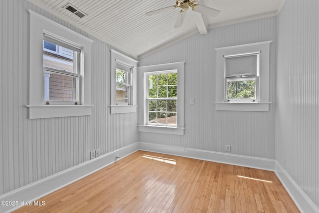 spare room with wood-type flooring, a wealth of natural light, and vaulted ceiling with beams