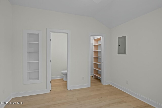 1615 Live Oak St Unit A & B, Beaufort, NC 28516 - unfurnished bedroom with baseboards, lofted ceiling, light wood-style flooring, electric panel, and a spacious closet