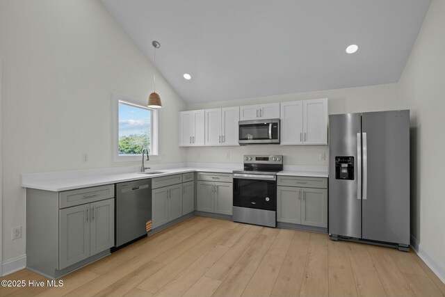 1615 Live Oak St Unit A & B, Beaufort, NC 28516 - kitchen with light wood finished floors, decorative light fixtures, vaulted ceiling, appliances with stainless steel finishes, and a sink