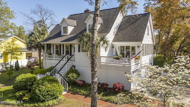 3001 E Yacht Dr, Oak Island, NC 28465 - view of front of property featuring a porch, roof with shingles, a chimney, and stairway