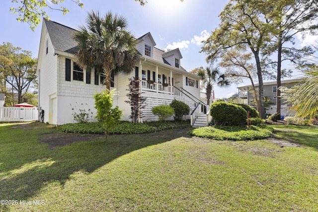 3001 E Yacht Dr, Oak Island, NC 28465 - view of front of home with fence, a front lawn, and stairs