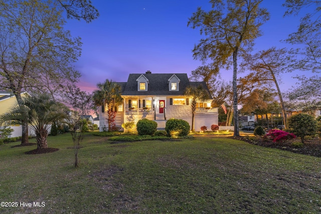 3001 E Yacht Dr, Oak Island, NC 28465 - cape cod house featuring a front lawn, covered porch, and a chimney