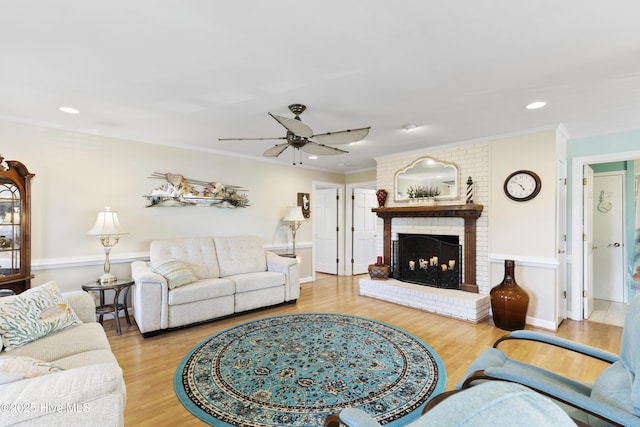 3001 E Yacht Dr, Oak Island, NC 28465 - living room featuring wood finished floors, ornamental molding, a fireplace, and a ceiling fan