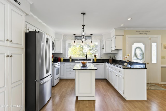 3001 E Yacht Dr, Oak Island, NC 28465 - kitchen featuring tasteful backsplash, a peninsula, a kitchen island, a sink, and stainless steel appliances