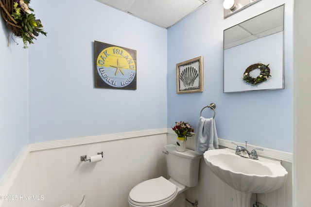 3001 E Yacht Dr, Oak Island, NC 28465 - bathroom featuring toilet, a wainscoted wall, and a sink
