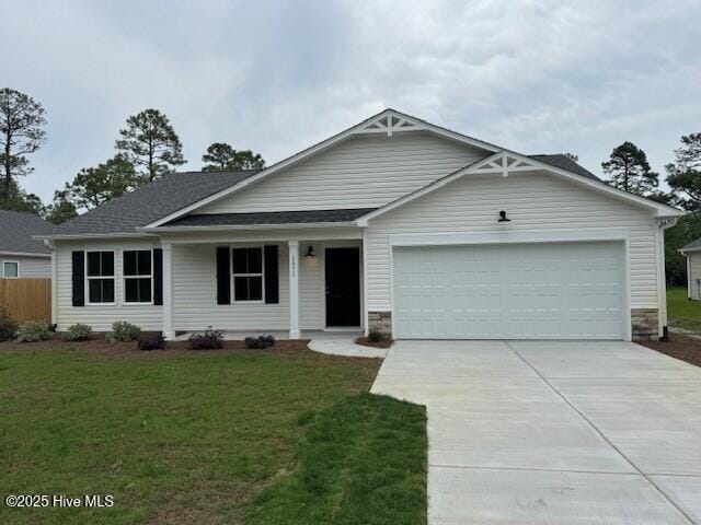view of front facade with a garage, concrete driveway, covered porch, and stone siding