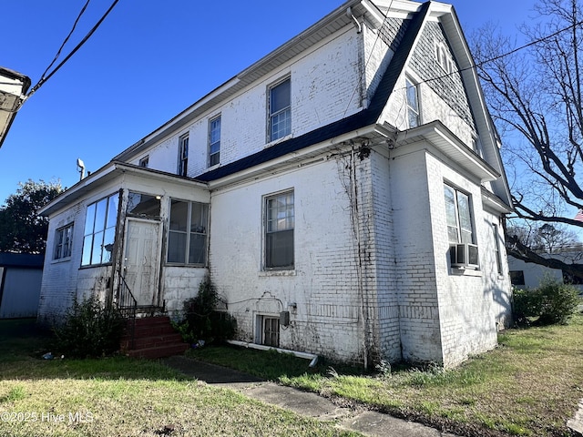exterior space with a yard and brick siding