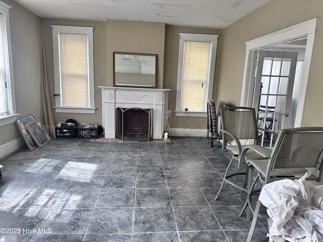 living room with a fireplace and baseboards
