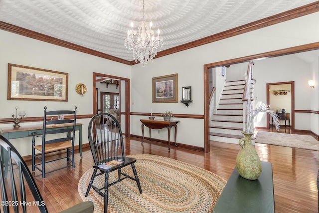 interior space with crown molding, stairway, an inviting chandelier, baseboards, and hardwood / wood-style floors