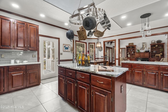 kitchen with crown molding, recessed lighting, light tile patterned floors, a center island, and hanging light fixtures