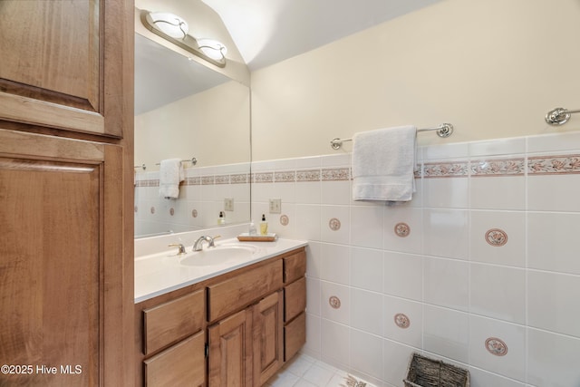 bathroom featuring vanity, tile walls, and wainscoting