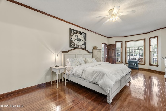 bedroom featuring dark wood-style flooring, ornamental molding, baseboards, and a textured ceiling
