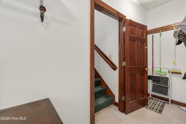interior space featuring tile patterned flooring, baseboards, and stairway