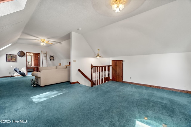 bonus room featuring baseboards, vaulted ceiling with skylight, ceiling fan, and carpet flooring