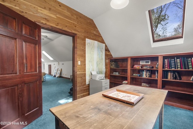 carpeted office space with wood walls and lofted ceiling with skylight