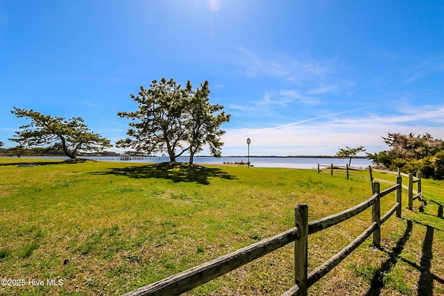 view of yard with a water view and fence