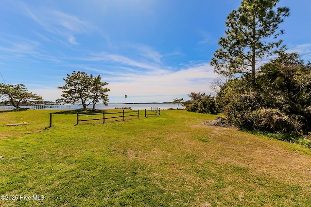 view of yard with a water view and fence
