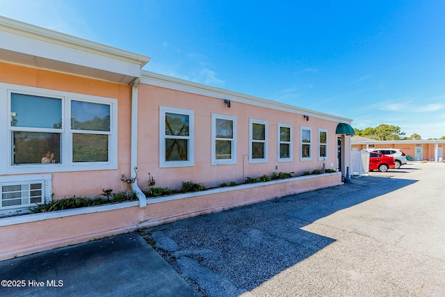 view of home's exterior featuring uncovered parking and stucco siding