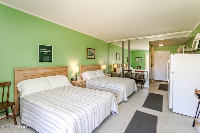 bedroom featuring ornamental molding and freestanding refrigerator