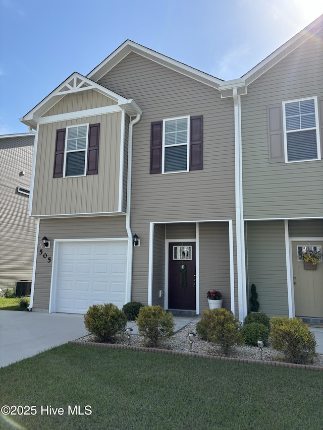 view of front of home with a front lawn, central AC, board and batten siding, an attached garage, and driveway