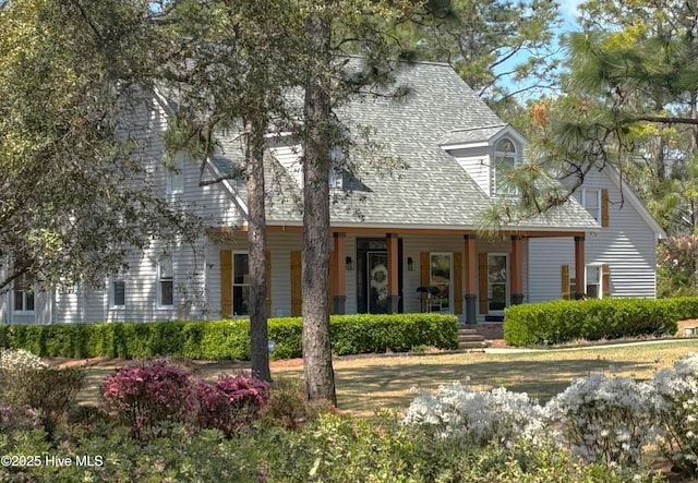cape cod home featuring a porch and roof with shingles