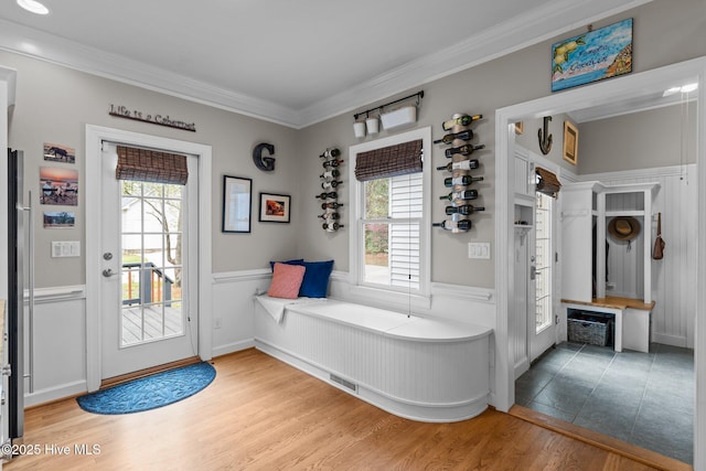 bathroom featuring crown molding, wainscoting, and wood finished floors