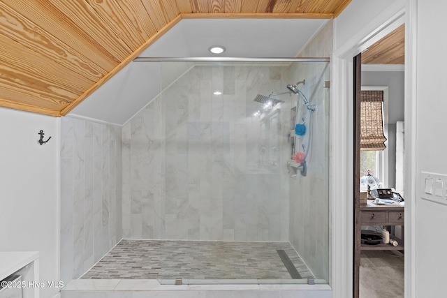 bathroom featuring ornamental molding, a tile shower, lofted ceiling, and wood ceiling