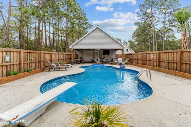 view of swimming pool featuring a patio area, a fenced backyard, a fenced in pool, and a diving board