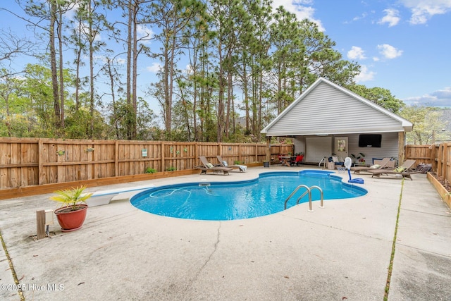 view of swimming pool featuring a fenced in pool, a diving board, a patio area, and a fenced backyard
