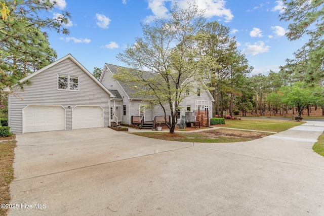 view of front of property with driveway, a garage, a wooden deck, and a front lawn