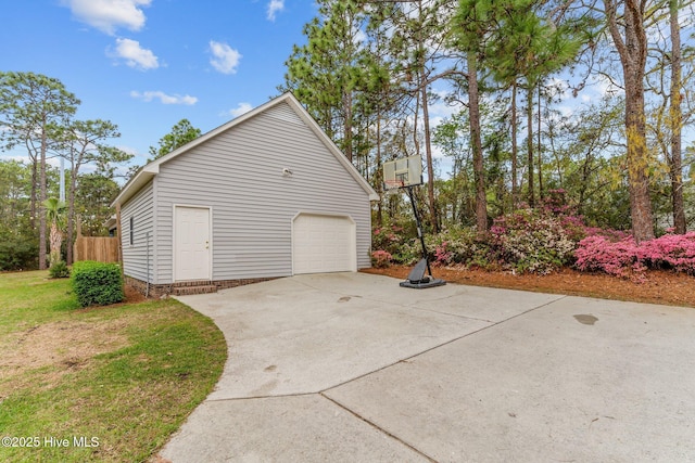 garage featuring fence and driveway