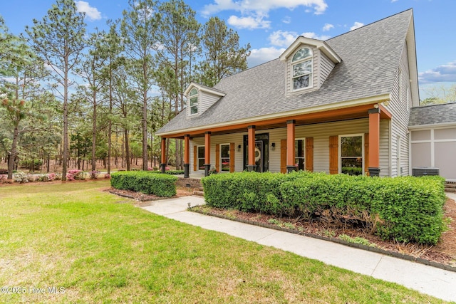 view of front of house featuring a porch, a shingled roof, and a front yard
