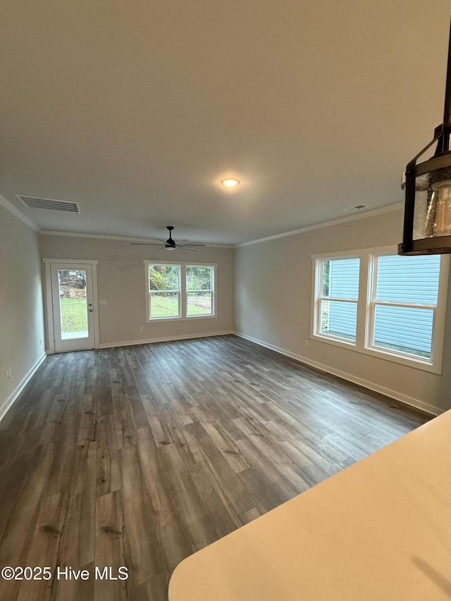 3572 Windy Point Rd SW, Supply, NC 28462 - unfurnished living room with ornamental molding, baseboards, dark wood-type flooring, ceiling fan, and healthy amount of natural light