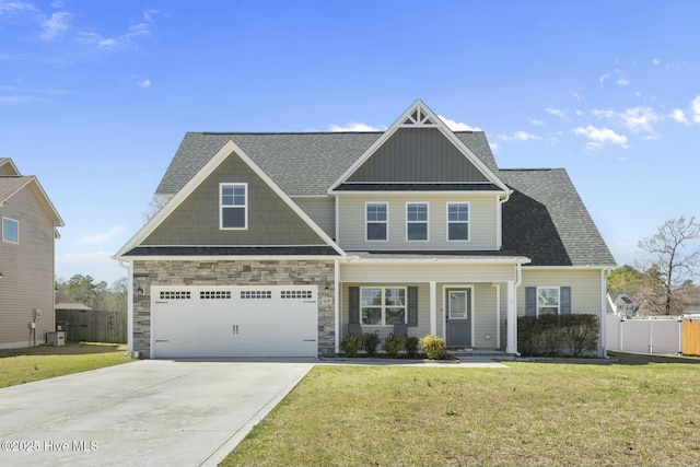 craftsman-style home featuring a garage, fence, a front lawn, and concrete driveway