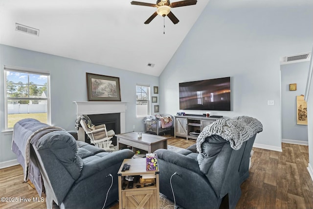 living room featuring wood finished floors, plenty of natural light, ceiling fan, and visible vents