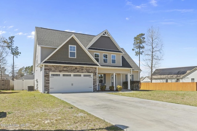 craftsman inspired home featuring fence, an attached garage, a front yard, driveway, and covered porch