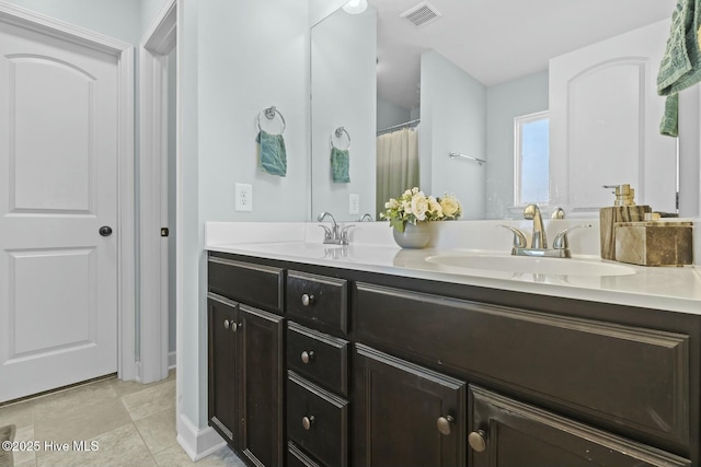 bathroom featuring double vanity, a sink, tile patterned flooring, and visible vents