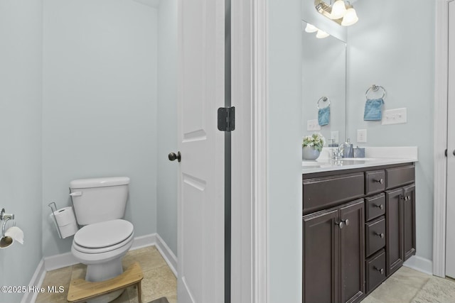 bathroom featuring baseboards, toilet, and vanity