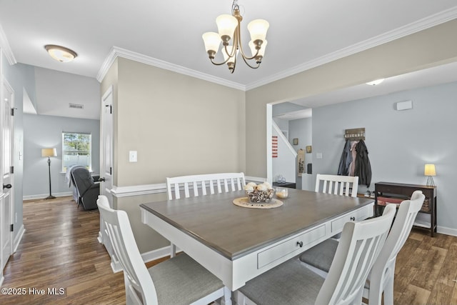 dining area with a notable chandelier, crown molding, wood finished floors, baseboards, and visible vents