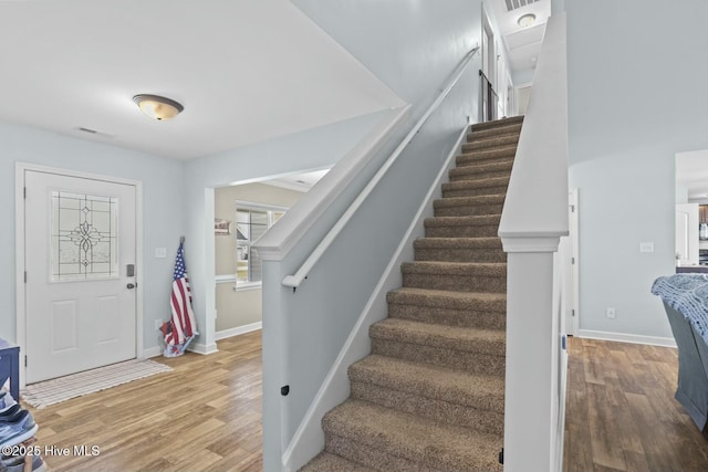 entrance foyer featuring light wood-style flooring, baseboards, and stairs