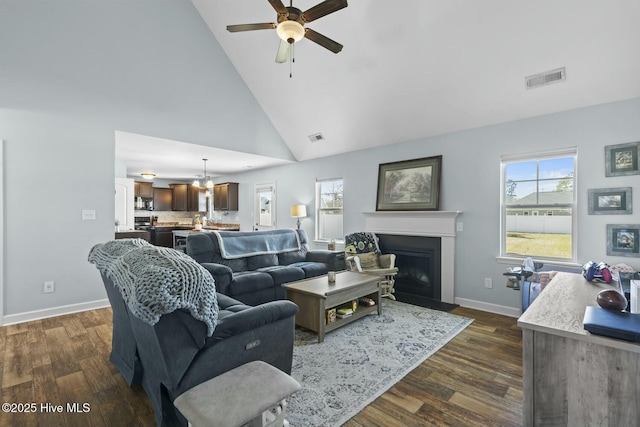 living area with a ceiling fan, dark wood-style flooring, a healthy amount of sunlight, and visible vents