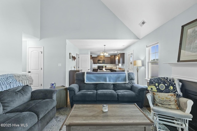 living room featuring visible vents, high vaulted ceiling, and an inviting chandelier