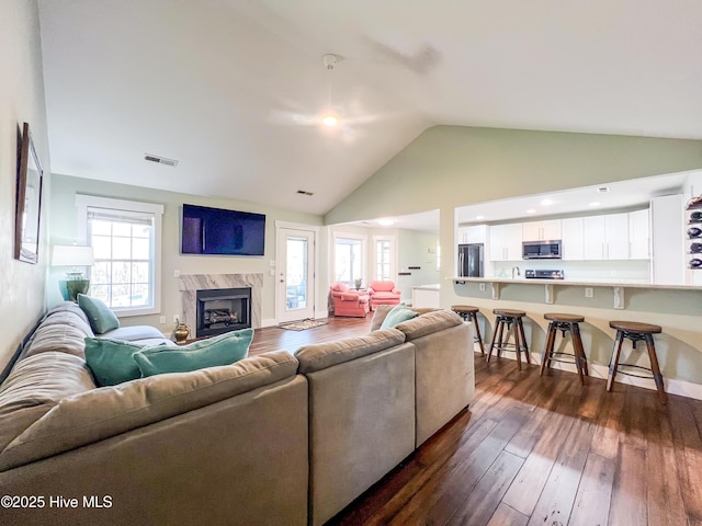 393 Knollwood Dr, Hampstead, NC 28443 - living room with dark wood-style flooring, lofted ceiling, healthy amount of natural light, and a high end fireplace