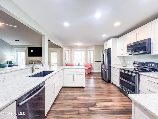 393 Knollwood Dr, Hampstead, NC 28443 - kitchen with stainless steel appliances, a sink, white cabinets, recessed lighting, and wood finished floors