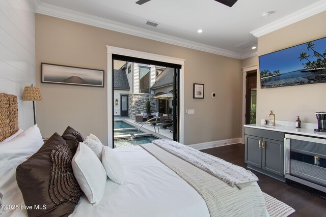 2941 Legends Dr, Southport, NC 28461 - bedroom featuring wine cooler, ornamental molding, dark wood finished floors, recessed lighting, and access to exterior