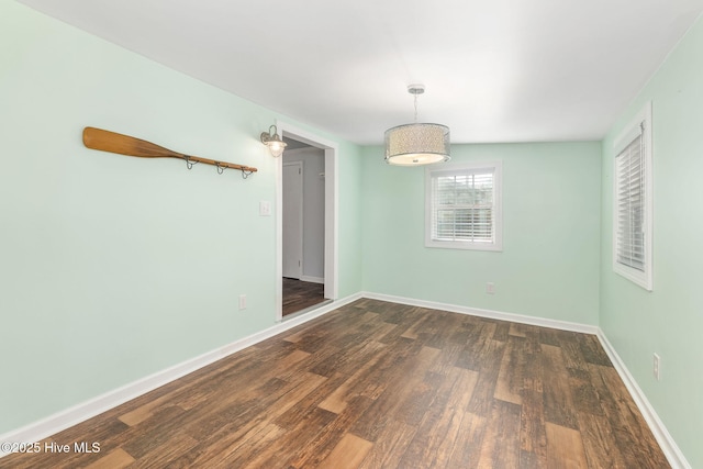 empty room featuring baseboards and wood finished floors